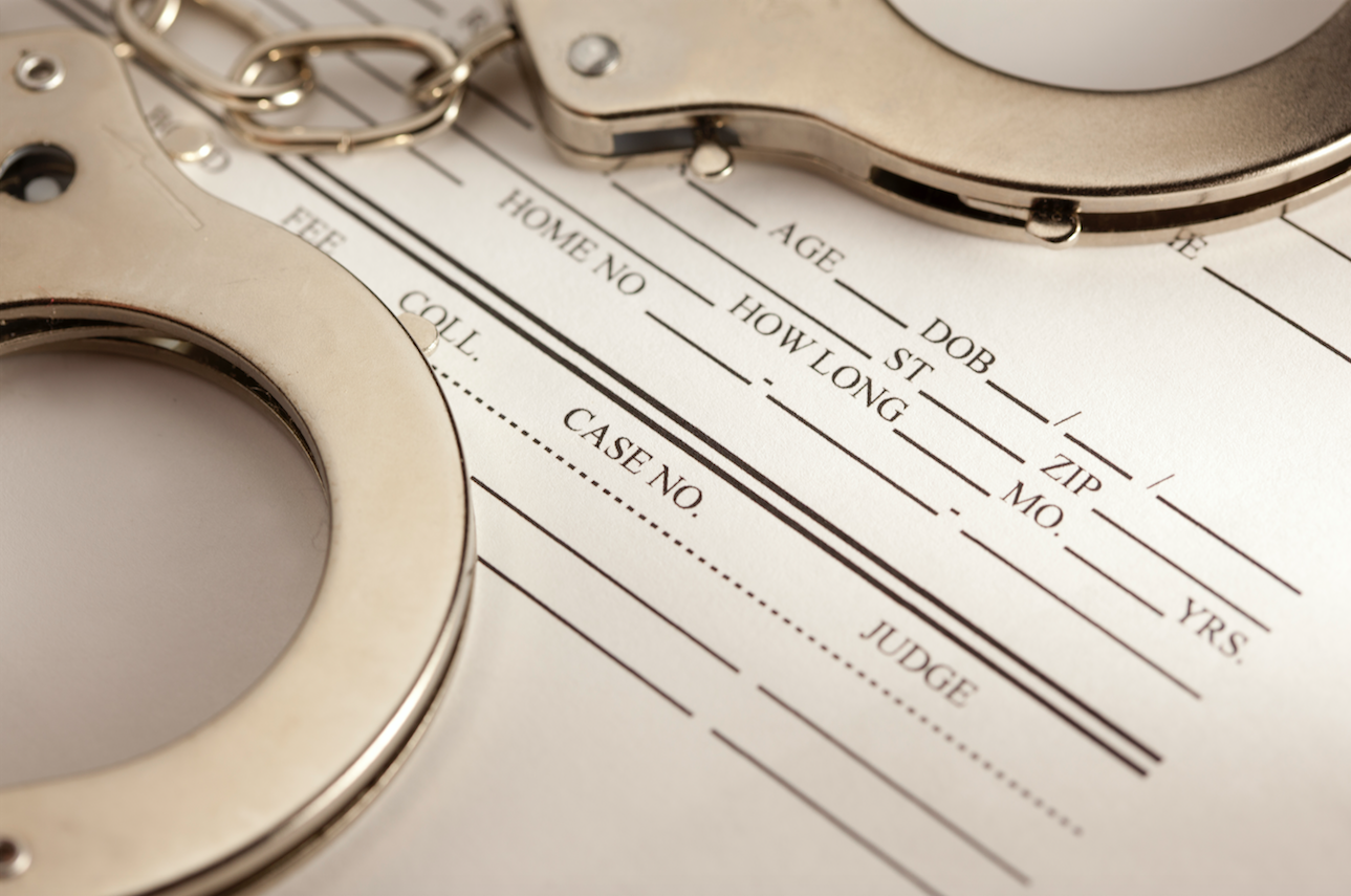 How to Get Your Criminal Record Expunged in Texas. Image of paperwork and handcuffs